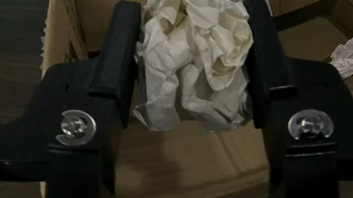 Wrist camera view of a handheld gripper's two fingers closing on crumpled paper
