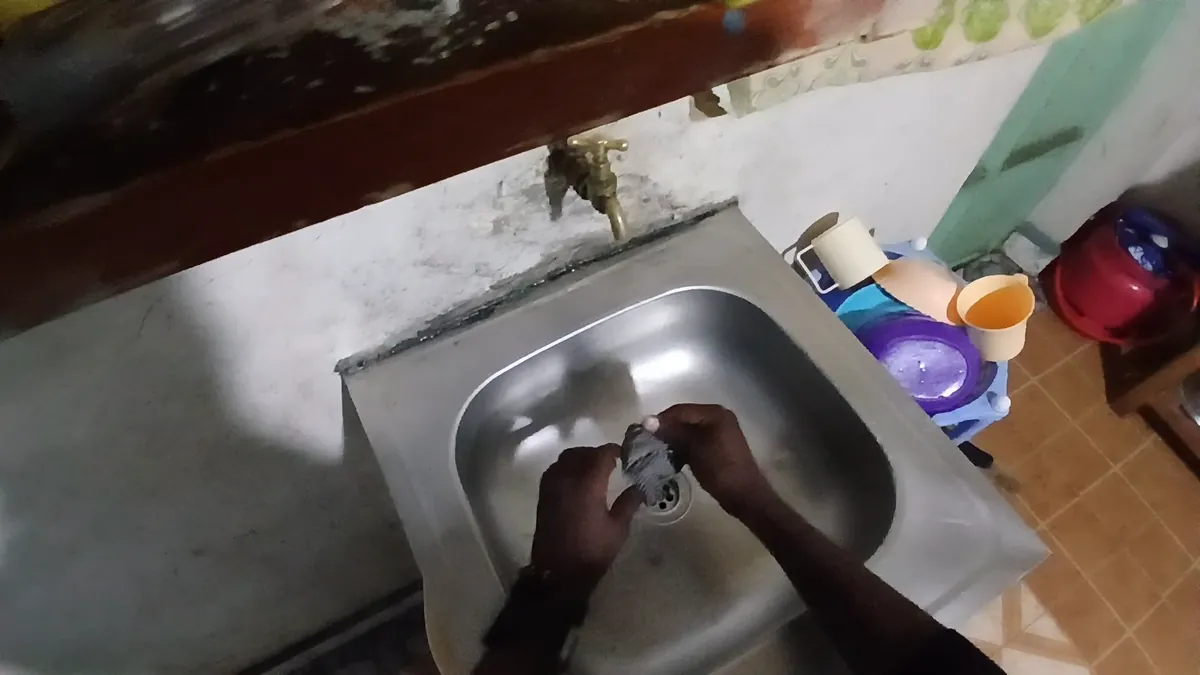 Head-mounted view of hands washing an item in a kitchen sink