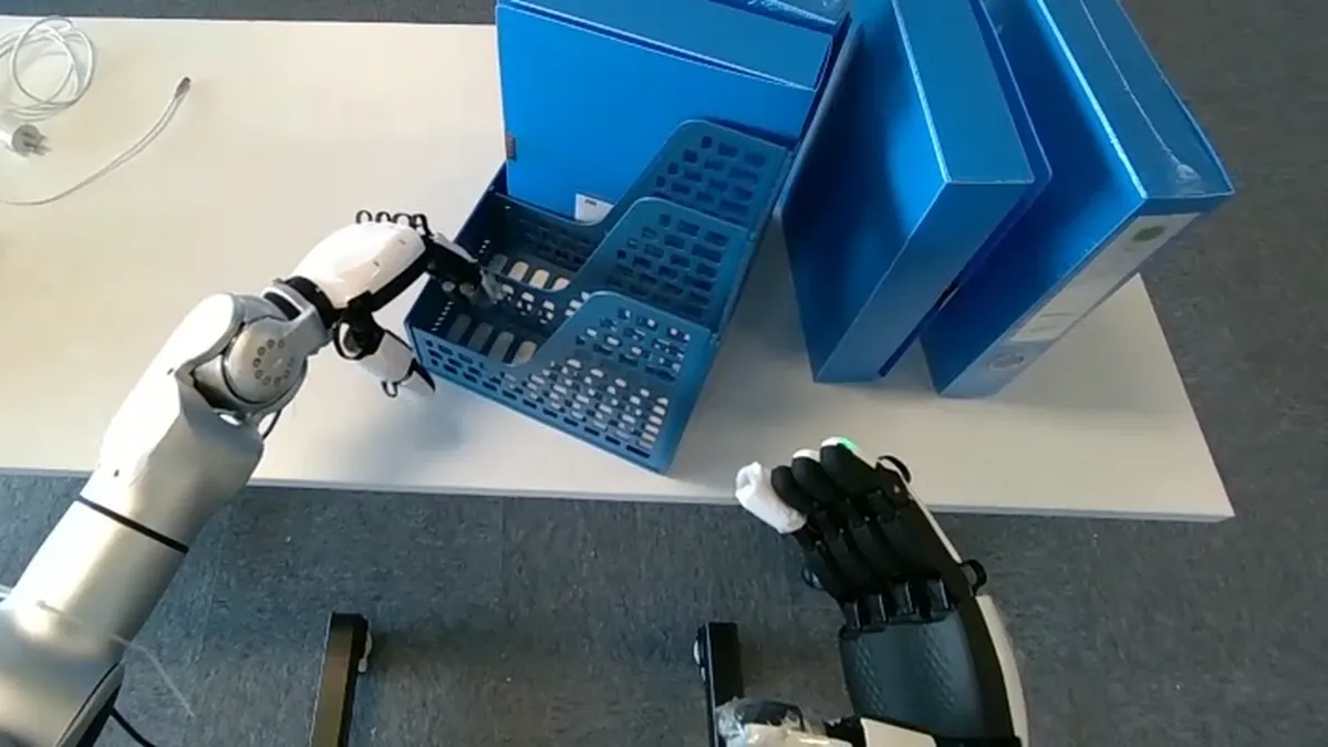 Head camera view of a humanoid's two dexterous robot hands sorting folders into a desk organizer