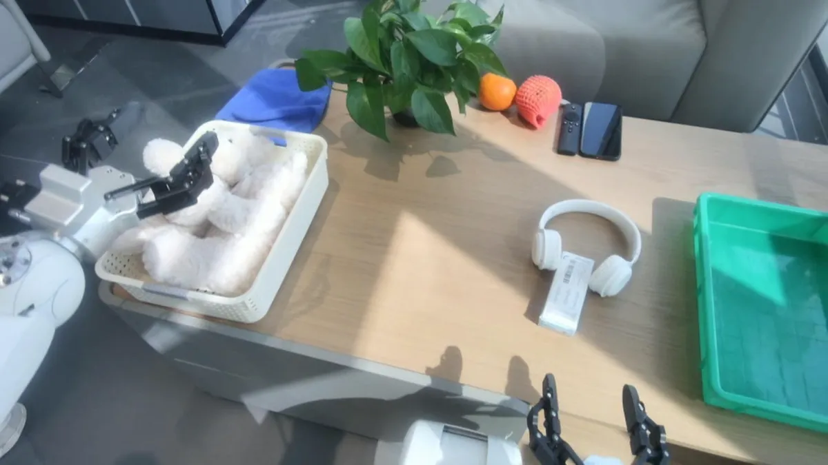 Head camera view of a robot gripper reaching into a basket of plush toys on a desk
